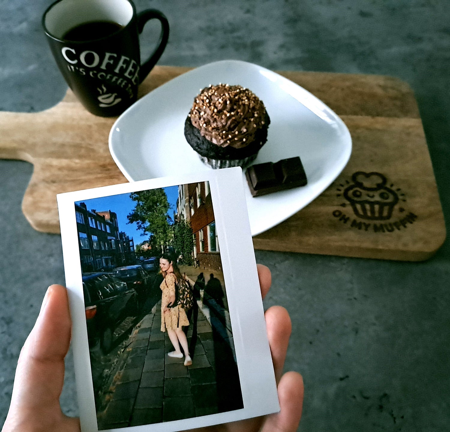 Second plan a cup of coffee and a vegan chocolate muffin on a wooden board. First plan a picture held in hand