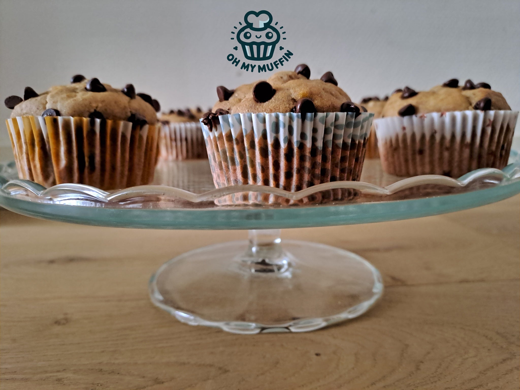 Plant-based banana chocolate chip muffins on a glass stand 
